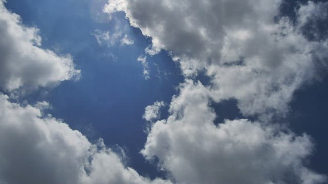 Blue sky background as the clouds travel blown by the wind.