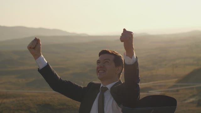 Entrepreneur who wears a suit celebrating.