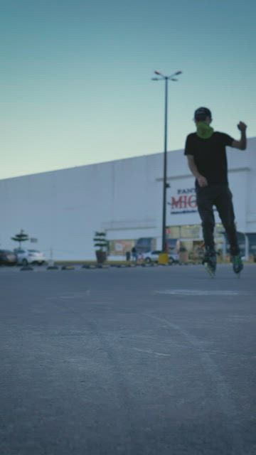 Urban boy with roller skates sliding and spinning in a parking lot.