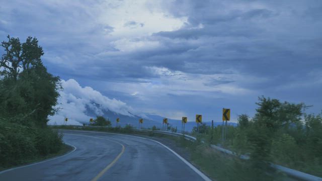 Going down a curved highway through a mountain range.