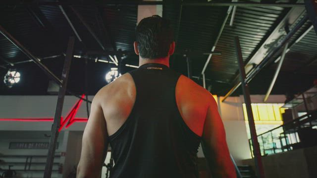 Muscular man doing pull-ups on a bar.