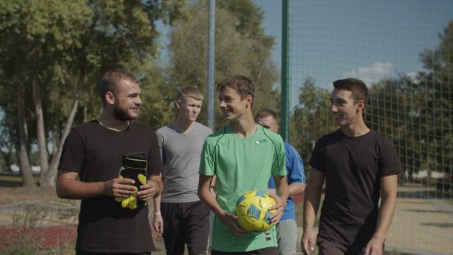 Men coming to play soccer football.