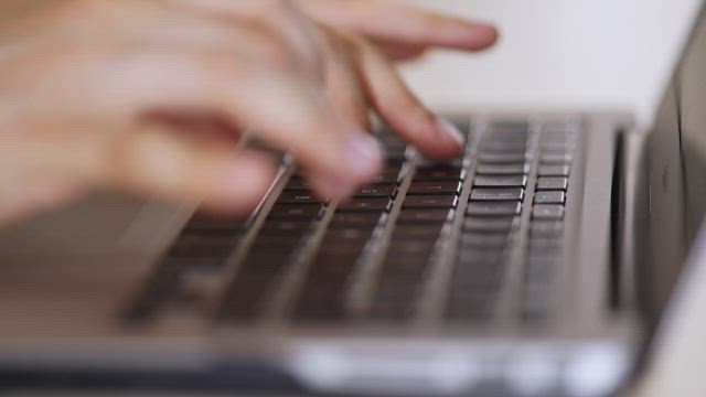 Person typing on a computer in detail.