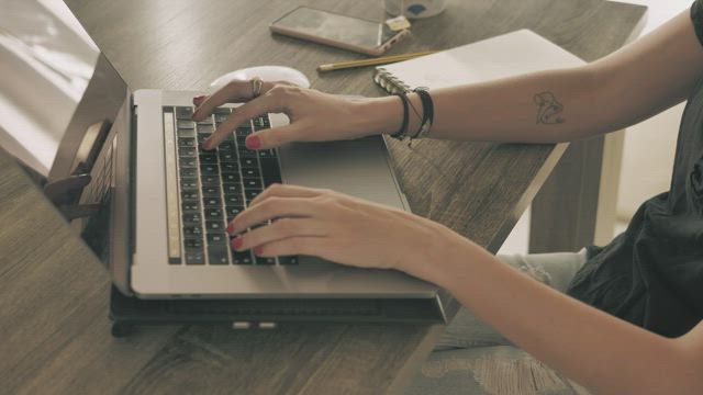 Hands of a girl working on a computer.