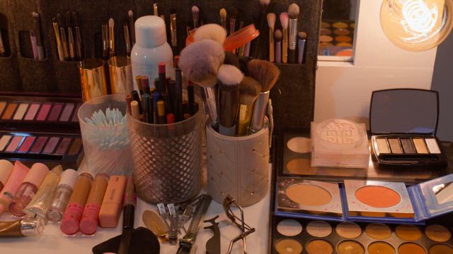 A complete and colorful set of makeup tool neatly arranged on the table for optimal use.