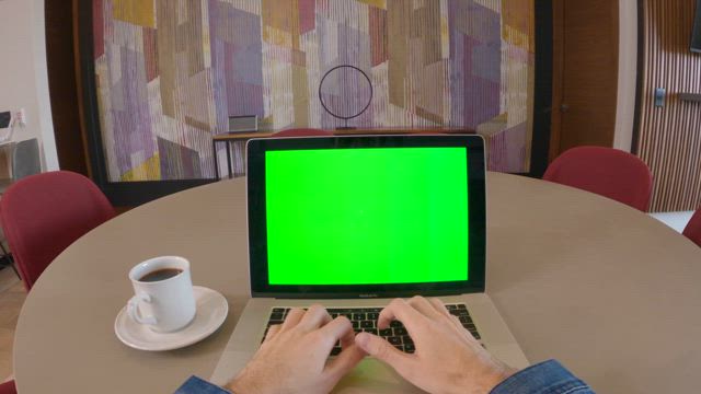 A young man usign a laptop on the table suddenly makes a hand gesture while navigating in the virtual world.