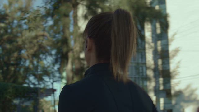 Back view of a young woman wearing a snugly black outfit immersed on her morning jog.