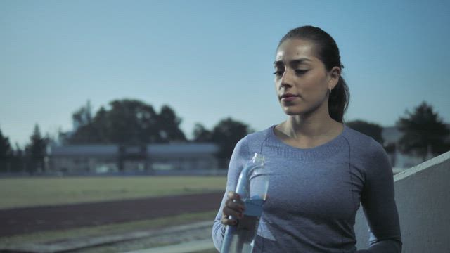 Woman drinks from water bottle.