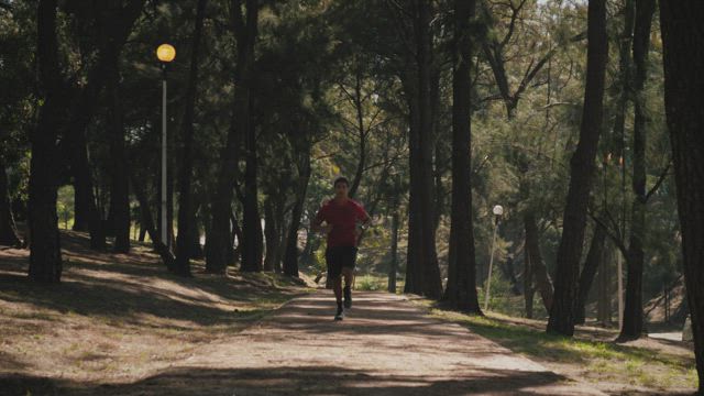 Man running on trail in the park.